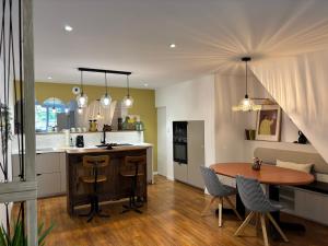 a kitchen and dining room with a table and chairs at Nid d argile - appartement neuf - 650m des Thermes - 1er étage in Salins-les-Bains