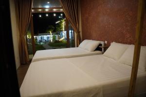 two beds in a room with a window at Old Village House in Yên Bài +52 photos