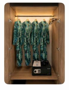 a wooden cabinet with two jackets and a radio at 1404, Building 1, Ocean Sky Forest - Flamingo Cat Ba in Cat Ba