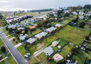 an aerial view of a town with houses and the ocean at Bungo Beach Shack in Eden