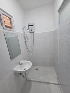 a white bathroom with a shower and a sink at 7641guesthouse in Basdiot