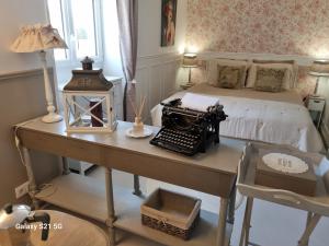 a bedroom with a bed and a desk with an old typewriter at L'escapade des Cévennes in Rousson