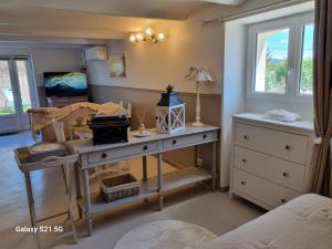 a room with a desk with a lamp and a bed at L'escapade des Cévennes in Rousson