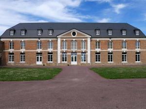 a large red brick building with a black roof at La Parenthèse in Le Plouy