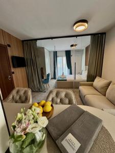 a living room with a couch and a table with flowers at Apartments Jovanovic - Alkima in Kotor