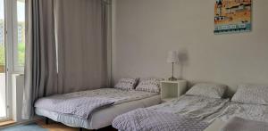 a bedroom with two beds and a window at Apartament Kolberga w Sopocie in Sopot