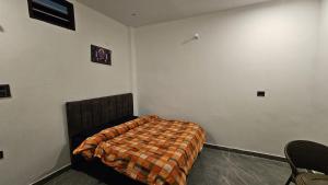 a bedroom with a bed with a blanket on it at Chill and Cheers Resort in Dehradun