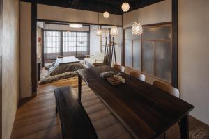 a living room with a wooden table and a bed at Tenjin 旅音 in Kanazawa