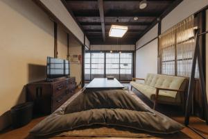 a bedroom with a large bed and a couch at Tenjin 旅音 in Kanazawa