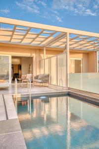 ein Swimmingpool vor einem Haus in der Unterkunft Thimios Suites Adults Only in Acharavi