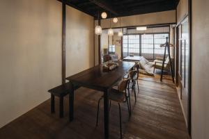 a dining room with a wooden table and chairs at Tenjin 旅音 in Kanazawa