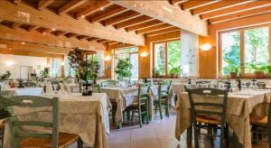 a dining room with tables and chairs in a building at Albergo Ristorante Il Laghetto in Fiumalbo