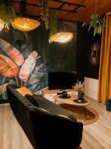 a living room with a couch and a table at SUITE KASSIOPEE, romantisme, balnéo, sauna in Quimperlé