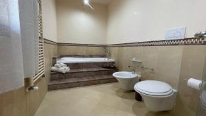 a bathroom with a tub and a toilet and a sink at B&B Il Cormorano in Scardovari