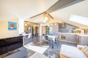 a kitchen and living room with a table and chairs at Le Princess in Évian-les-Bains