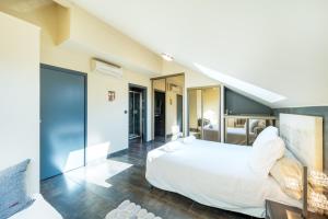 a bedroom with a large white bed and a staircase at Le Princess in Évian-les-Bains