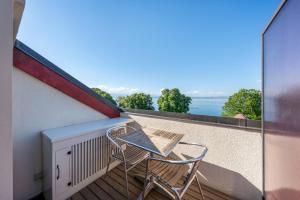 a chair on a balcony with a view of the ocean at Le Princess in Évian-les-Bains