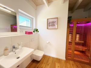 a bathroom with a sink and a toilet and a window at Ferienhaus Fischkopf mit Sauna und Strandkorb in Büsum