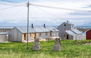 ein altes Bauernhaus mit zwei Steinsäulen auf einem Feld in der Unterkunft Villa Lofoten - Edvardbua in Kvalnes
