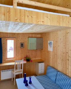 eine Küche mit einem Tisch und einer blauen Couch in einem Zimmer in der Unterkunft Villa Lofoten - Edvardbua in Kvalnes