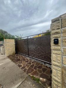 a fence with a gate with a stone wall at Dream House in San Giovanni Suergiu