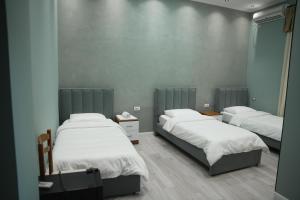 a room with three beds in a room at Hotel haliti kukes in Kukës