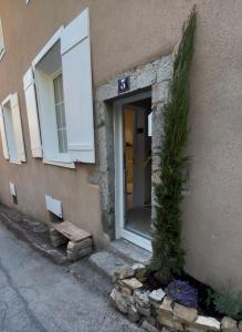 a building with a door and a tree next to it at Nid d argile - appartement neuf - 650m des Thermes - 1er étage in Salins-les-Bains +9 photos