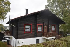 a black and white house with red windows at Ferienwohnung Angela in Thalfang