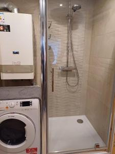 a shower in a bathroom with a washing machine at Ferienwohnung Angela in Thalfang