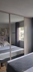 a bedroom with a bed and a mirror at Les Lavandins,Chambre climatisé, à 300 Tram L5, PARKING et WIFI gratuit in Montpellier