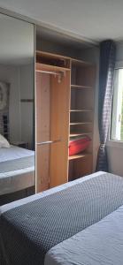 a bedroom with a bed and a closet with shelves at Les Lavandins,Chambre climatisé, à 300 Tram L5, PARKING et WIFI gratuit in Montpellier