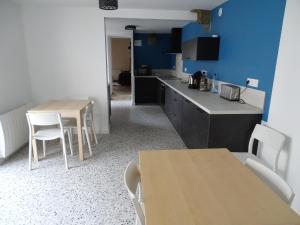 a kitchen with two tables and a counter with chairs at Bryce Canyon in Châteaubourg +1 photo