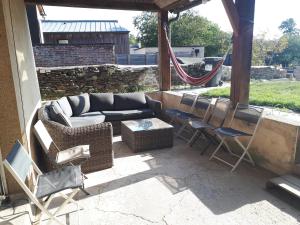 a patio with a couch and chairs and a hammock at Bryce Canyon in Châteaubourg
