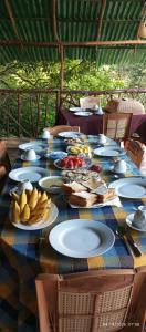 a long table with plates of food on it at Friendship Villa-Ella in Nikawatawana