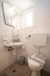 a bathroom with a toilet and a sink and a mirror at Nisaki Summer Stay Studios in Agia Ermioni +36 photos