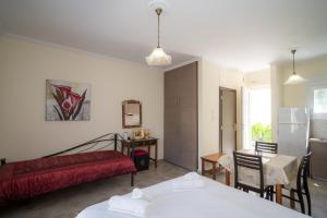 a room with two beds and a table and a refrigerator at Nisaki Summer Stay Studios in Agia Ermioni