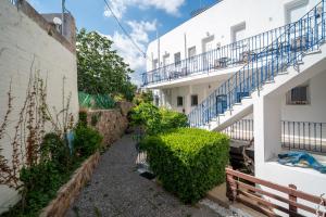 a corridor of a building with stairs and plants at Nisaki Summer Stay Studios in Agia Ermioni