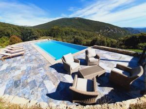 a patio with chairs and a swimming pool at Le mas des louquiers in Mons