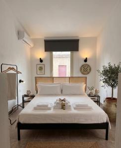 a bedroom with a large white bed with two books on it at Be Local-Avola stay in Avola