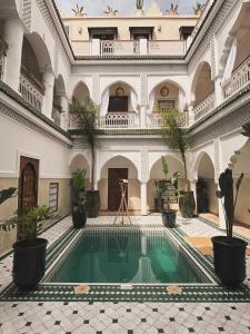 a courtyard with a swimming pool in a building at Riad Aura Suites & Spa in Marrakesh