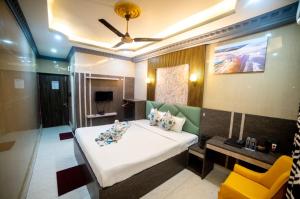 a bedroom with a large bed and a yellow chair at Hotel Priyadarshini in Digha