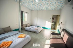 a room with two beds and a couch in it at ป้าแมว โฮมสเตย์ in Ban Pok Nai