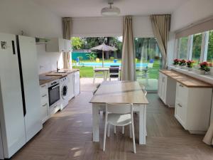 a kitchen with white cabinets and a table and a dining room at Casa Rural El Pinar de Jesus in Arcos de la Frontera
