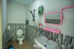 a bathroom with a sink and a toilet and a mirror at ป้าแมว โฮมสเตย์ in Ban Pok Nai