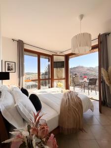a bedroom with a large white bed and a balcony at Elegant Penthouse LA BALCONATA - Wellness Retreat & Castle View in Tabiano