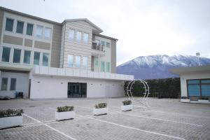 a building with potted plants in a parking lot at Hotel haliti kukes in Kukës +20 photos