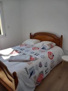 a bed with a comforter with stickers on it at L'Olivier in Les Mazures