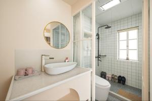 a bathroom with a sink and a toilet and a mirror at Shanghai WanTing Villa Hotel in Shanghai