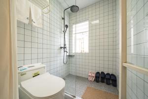 a white bathroom with a toilet and a window at Shanghai WanTing Villa Hotel in Shanghai
