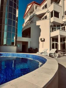 a house with a swimming pool in front of a building at Hotel Dabi Imperial in Donji Štoj